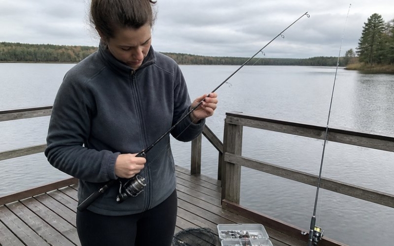 Angelanfänger mit Spinnrute am See