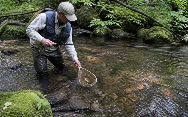 Angler an einem Forellenbach mit leichter Rute